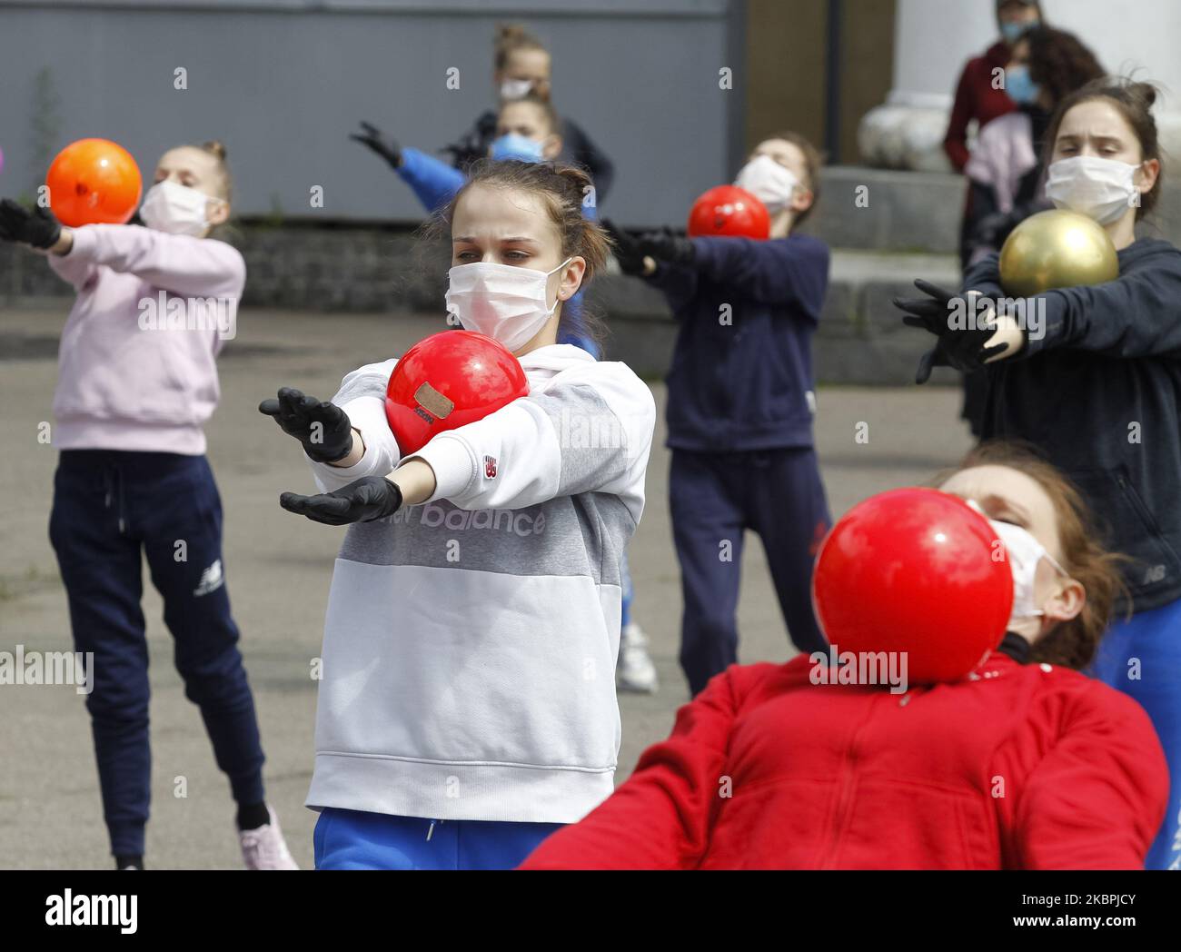 Gymnasts of the Deriugina School wearing protective masks amid the Covid-19 coronavirus epidemic take part at a trainning session on a street in central Kyiv, Ukraine, on 01 June, 2020. Young gymnasts had a training on a street to support the 'Save Deriugina School' action, which was organized in support of Irina Deryugina children's and youth sports school of gymnastics. (Photo by STR/NurPhoto) Stock Photo