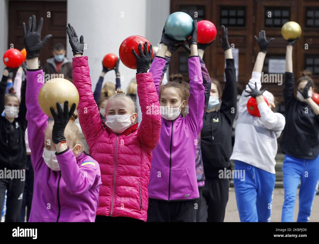 Gymnasts of the Deriugina School wearing protective masks amid the Covid-19 coronavirus epidemic take part at a trainning session in central Kyiv, Ukraine, on 01 June, 2020. Young gymnasts had a training on a street to support the 'Save Deriugina School' action, which was organized in support of Irina Deryugina children's and youth sports school of gymnastics. (Photo by STR/NurPhoto) Stock Photo