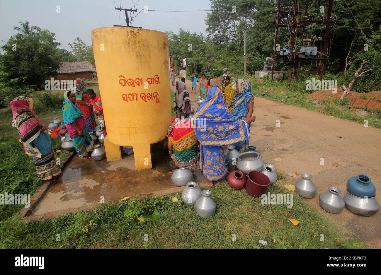 Villagers gathered at a public supply water tank to collect drinking water for their family in a hot summer day outskirts of the eastern Indian state Odishaâ€™s capital city Bhubaneswar on June 2, 2020. (Photo by STR/NurPhoto) Stock Photo