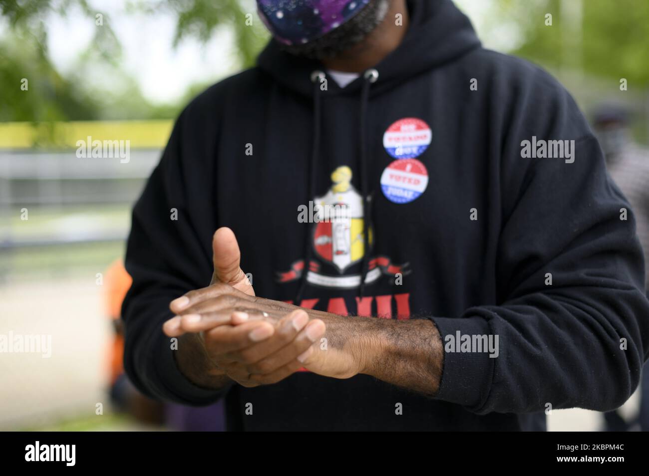Voters receive hand sanitizer from a poll worker outside a poling station in the Mt Airy neighborhood of Northwest Philadelphia, PA on June 2, 2020. This Election Day - with condensed polling places for in-person voting due to COVID-19 - the community also prepares and board up against an of possibilities of violence and vandalism (Photo by Bastiaan Slabbers/NurPhoto) Stock Photo