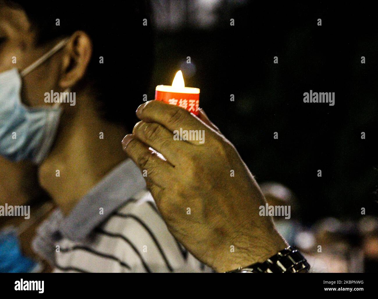 A resident holds up a candle to mark 31 years since the Tiananmen