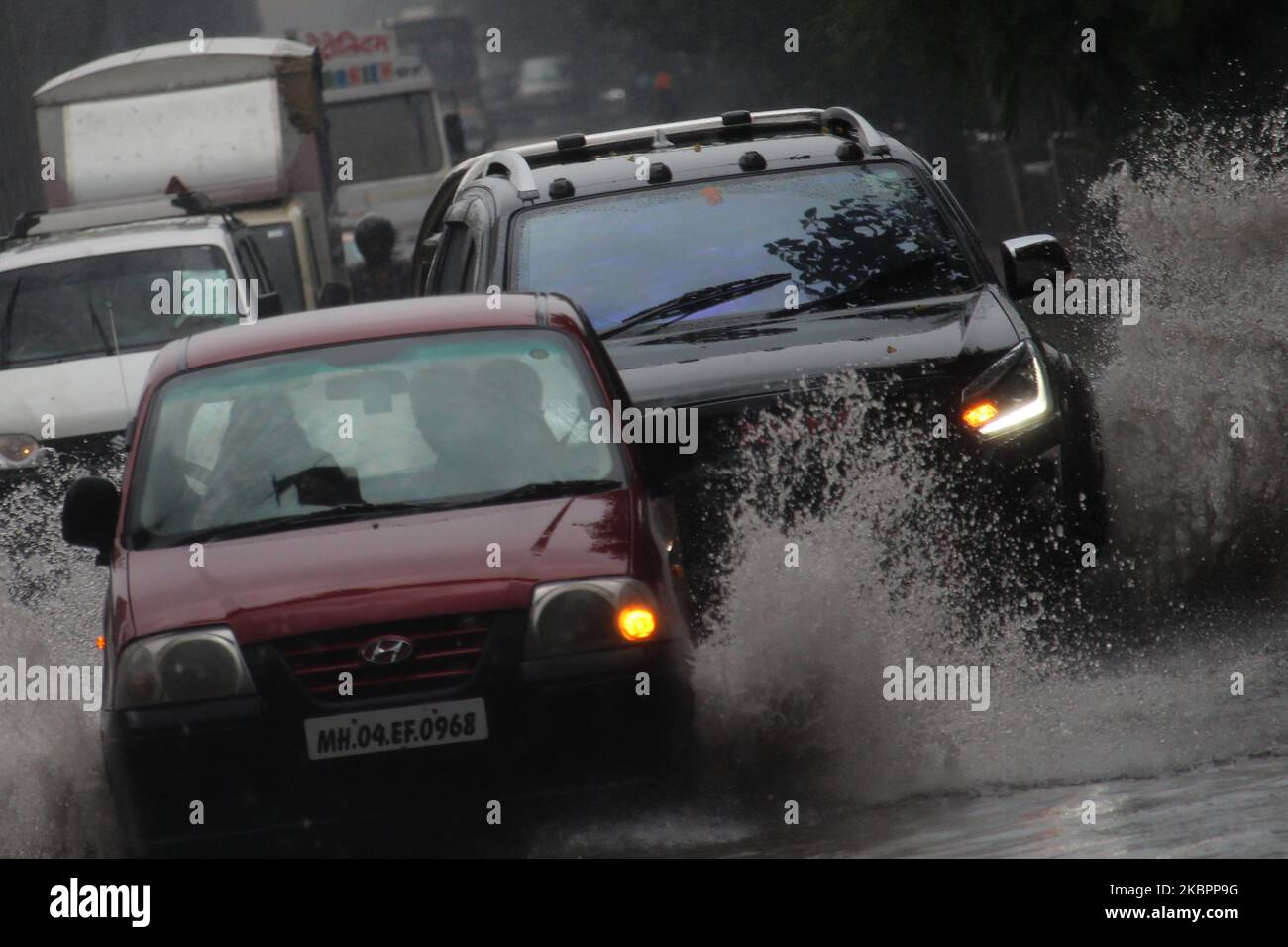 Cars drive through flood waters during heavy rains in Mumbai, India on