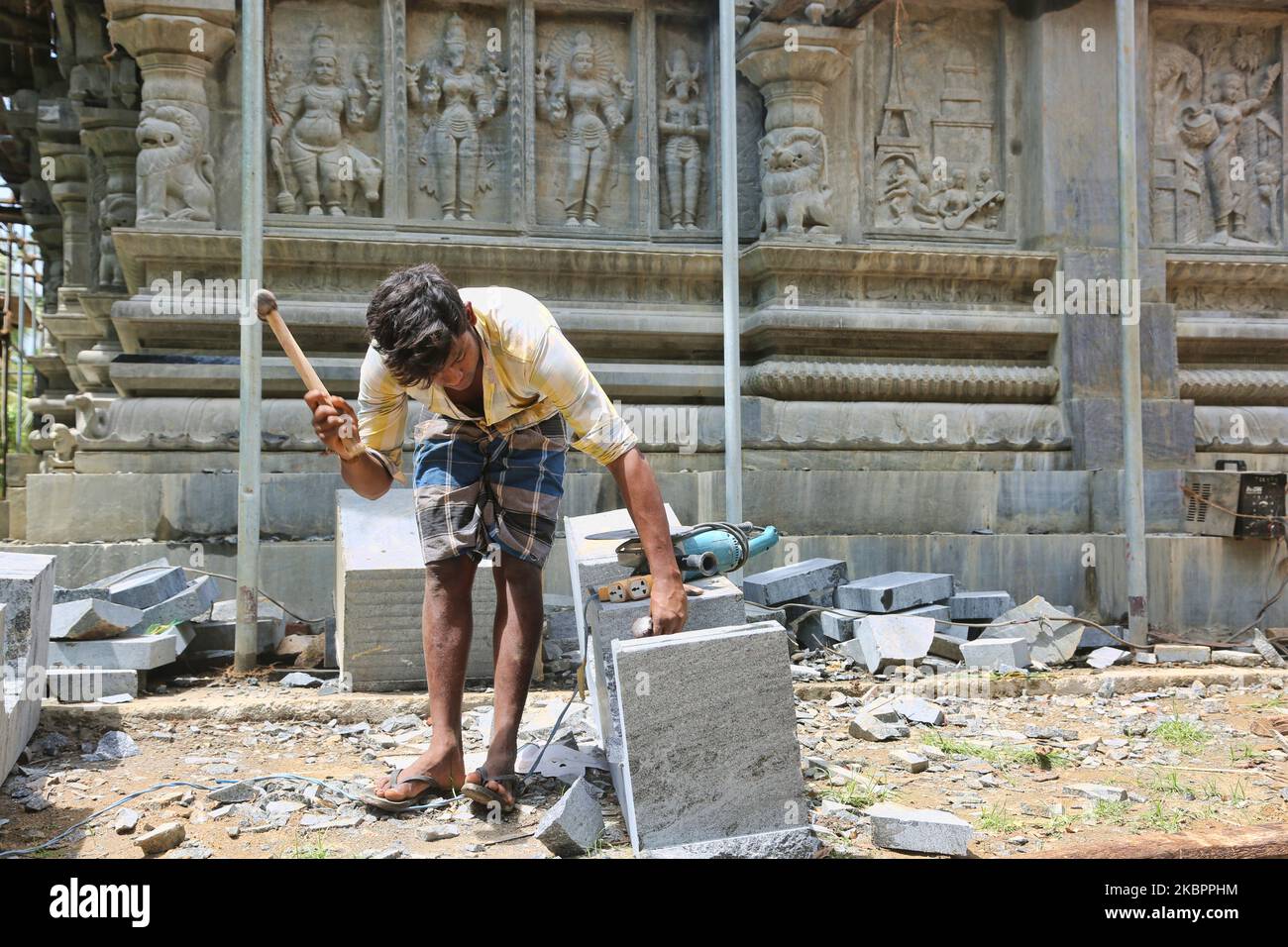 Worker chisels stone during reconstruction of the Raja Gopuram tower