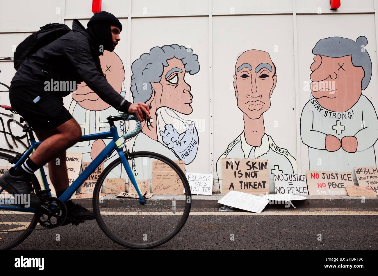 A cyclist rides past a mural painted onto wooden sheeting on Parliament Street as Black Lives Matter activists, gathered for the second consecutive day of mass protest against racism, demonstrate in London, England, on June 7, 2020. Today marked the fourth massive Black Lives Matter protest in London in eight days, amid a global wave of anti-racism demonstrations sparked by the killing in police custody of a black man, George Floyd, in the US city of Minneapolis on May 25. (Photo by David Cliff/NurPhoto) Stock Photo