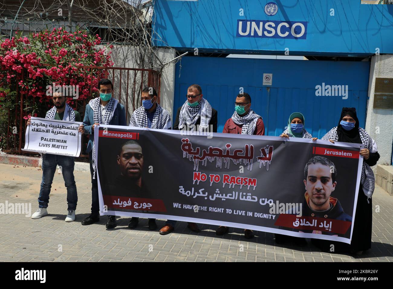 Palestinians gesture as others hold a banner with pictures of George Floyd, who died in Minneapolis police custody, and Iyad al-Halaq, an unarmed autistic Palestinian who was shot dead by Israeli police, during a protest against racial inequality, in Gaza City June 11, 2020. (Photo by Majdi Fathi/NurPhoto) Stock Photo