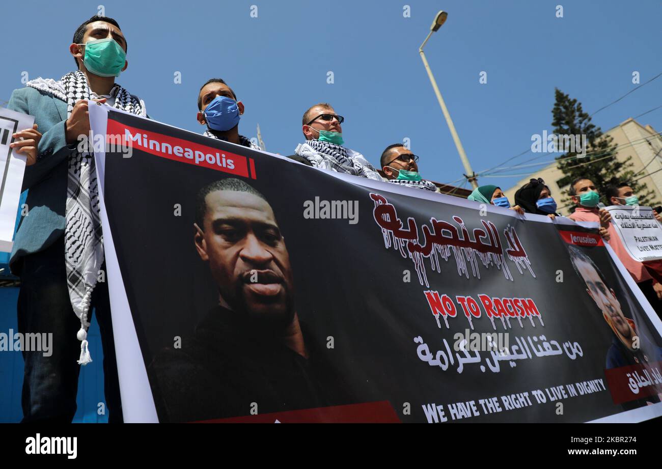 Palestinians gesture as others hold a banner with pictures of George Floyd, who died in Minneapolis police custody, and Iyad al-Halaq, an unarmed autistic Palestinian who was shot dead by Israeli police, during a protest against racial inequality, in Gaza City June 11, 2020. (Photo by Majdi Fathi/NurPhoto) Stock Photo