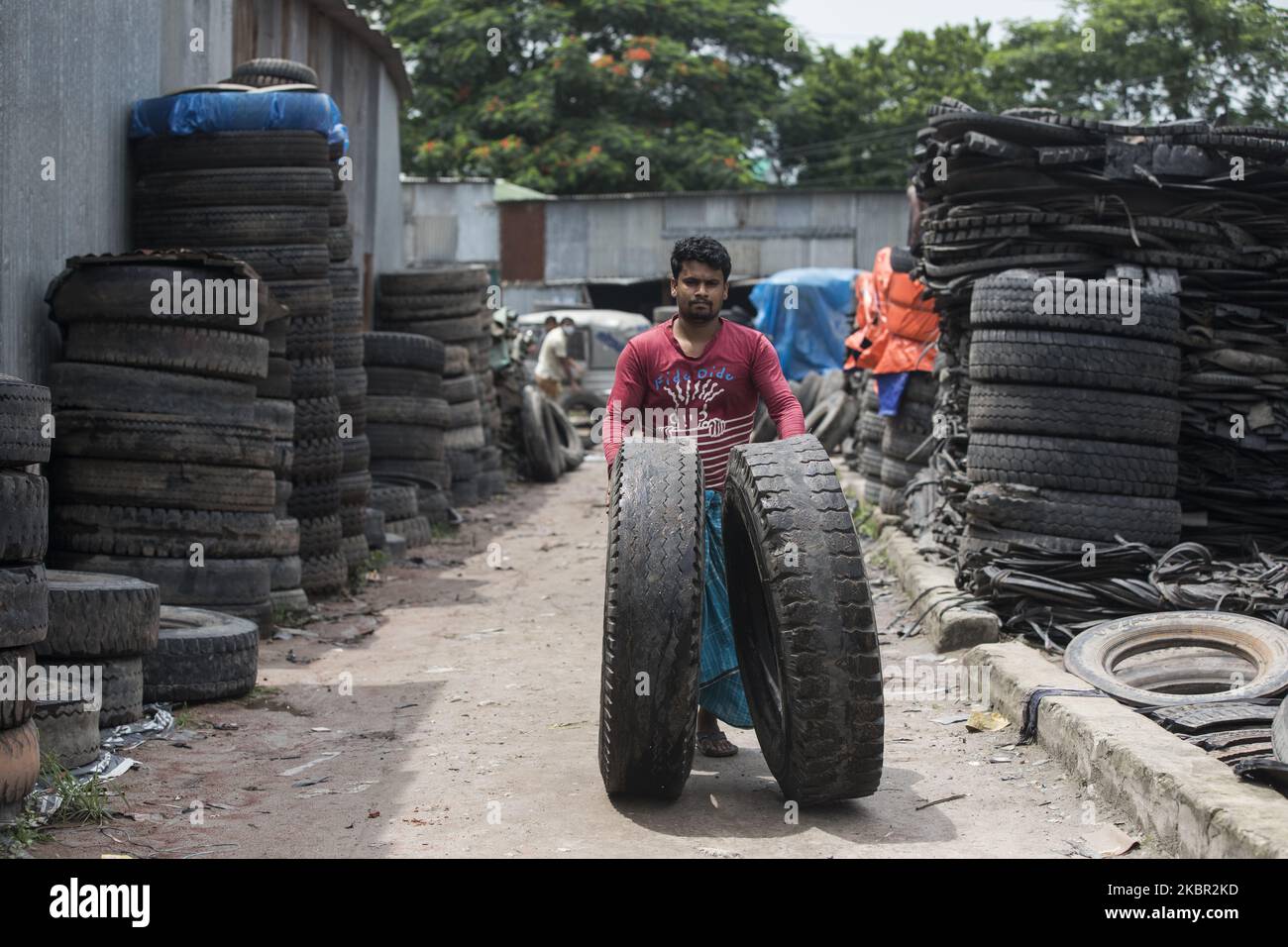 Laborer rolles old tyres hi-res stock photography and images - Alamy