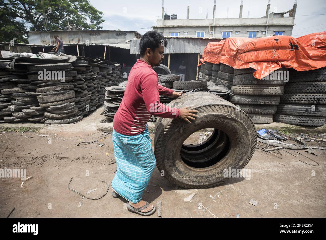 Laborer rolles old tyres hi-res stock photography and images - Alamy