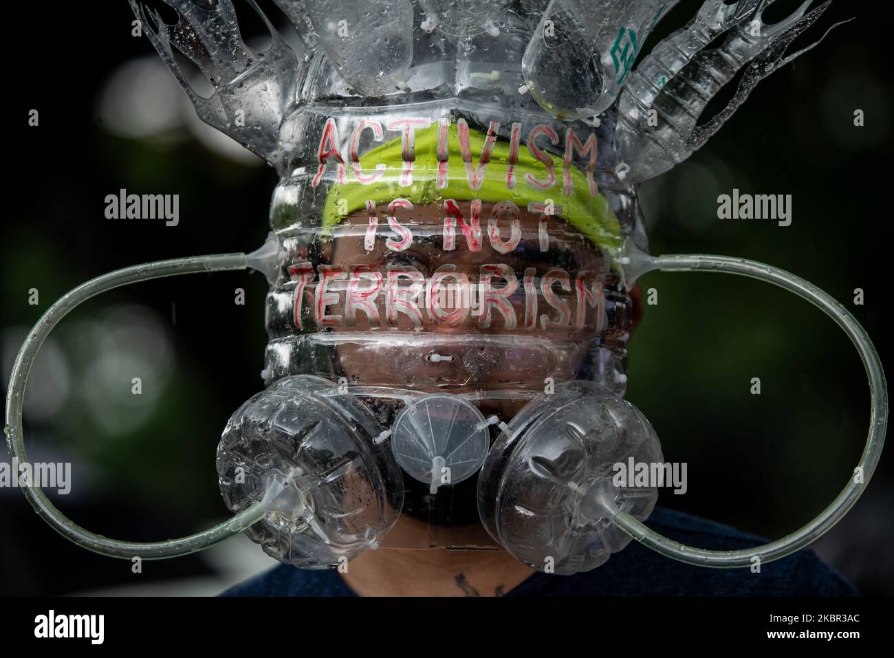 A man wearing a face shield made of recycled materials joins a protest ...