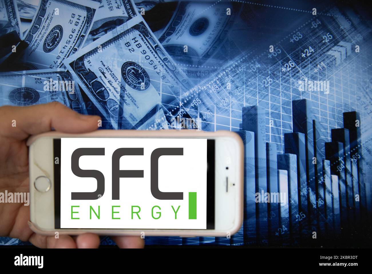 In this illustration is displayed on a smartphone's screen the company logo of SFC Energy, which specialises in mobile energy solution for the clean energy, is shown on the screen of a smartphone in front of a blue backdrop of the global stock markets and worldwide indices in Frankfurt, Germany, on 12th June, 2020. It is one of the global companies that focuses on devising strategies for effective power management in the energy industry. (Photo Illustration by Alexander Pohl/NurPhoto) Stock Photo