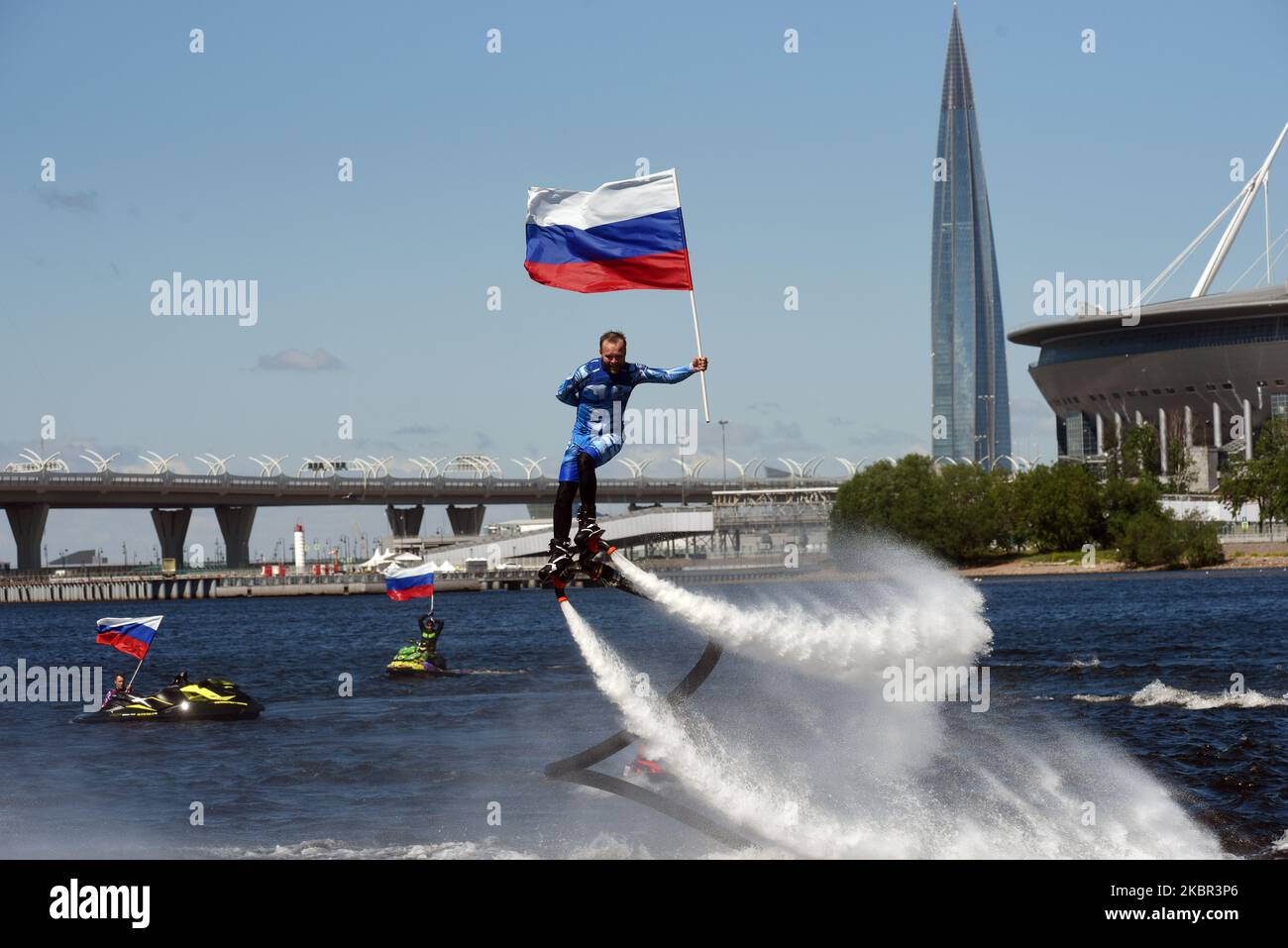 A member of the Russian hydroflight team performs holding the Russian national flag during the Day of Russia celebration on June 12, 2020 in St. Petersburg, Russia. (Photo by Sergey Nikolaev/NurPhoto) Stock Photo