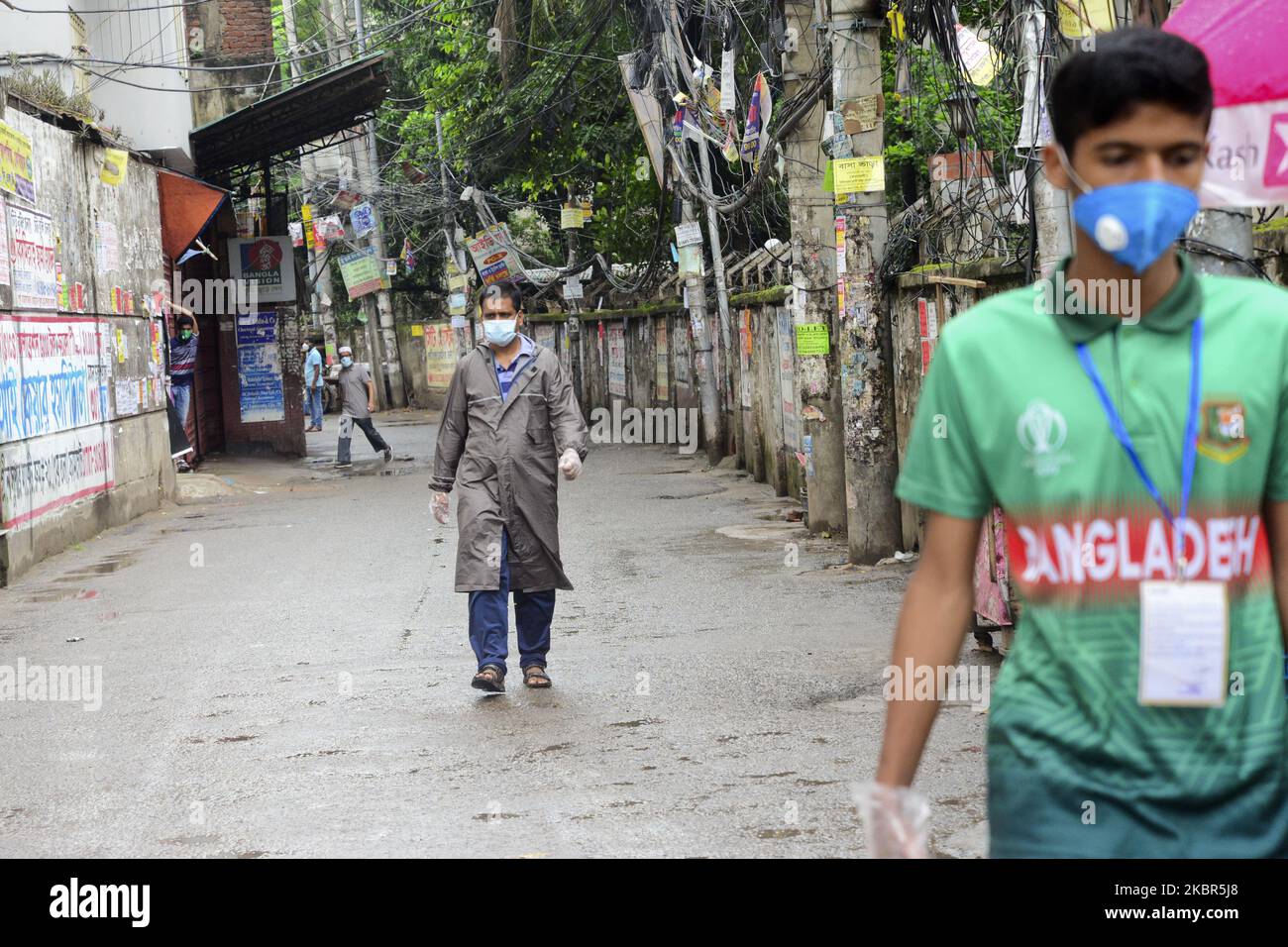 Residents wearing Facemask get out in an emergency after registration from the government imposed coronavirus red zone with maximum infection risk at East Rajabazar in Dhaka, Bangladesh.on June 14, 2020.The authorities put East Rajabazar in Dhaka on total lockdown from June 10, allowing no one to leave or enter the area, after it was declared coronavirus red zone with maximum infection risk. (Photo by Mamunur Rashid/NurPhoto) Stock Photo