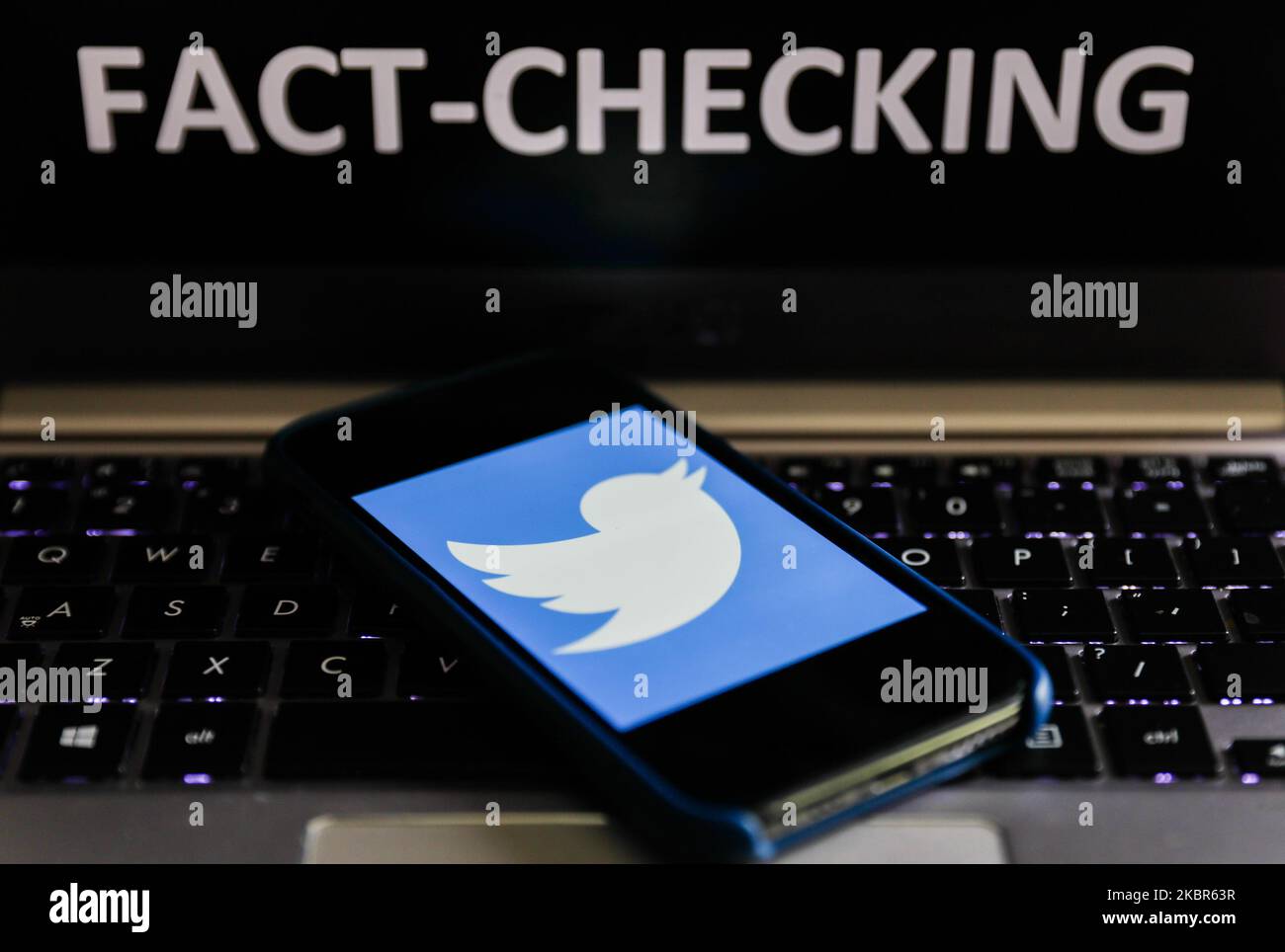 'Fact-checking' sign displayed on a laptop and Twitter logo displayed on a phone screen are seen in this illustration photo taken in Poland on June 13, 2020. European Commission officials said that Facebook, Twitter and Google should provide monthly fake news reports to prevent fake news about coronavirus pandemic. (Photo Illustration by Jakub Porzycki/NurPhoto) Stock Photo