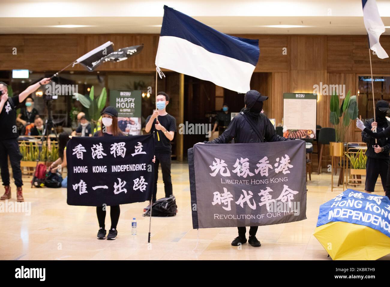 Pro Democracy supporters hold Hong Kong Independence signs and chant slogans such as 'One Nation, One Hong Kong' while waving what some say is the 'New Hong Kong Flag' as members of the public queue for hours to pay respects on the one year anniversary of the death of Marco Leung Ling-Kit who fell to his death in 2019 on June 15, 2020 in Hong Kong, China.(Photo by Simon Jankowski/NurPhoto) Stock Photo