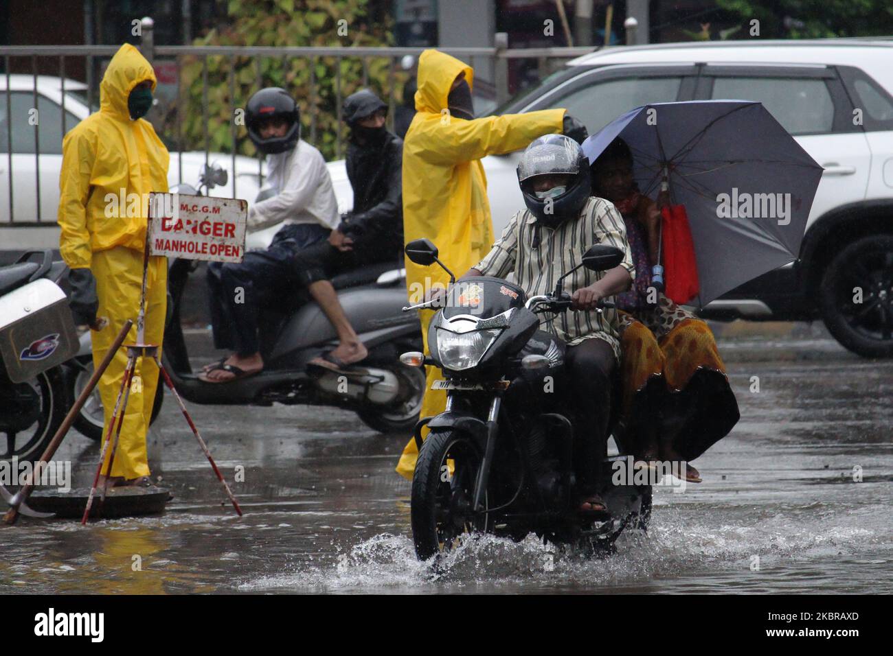 A man rides a motorcycle through flood waters after heavy rains in