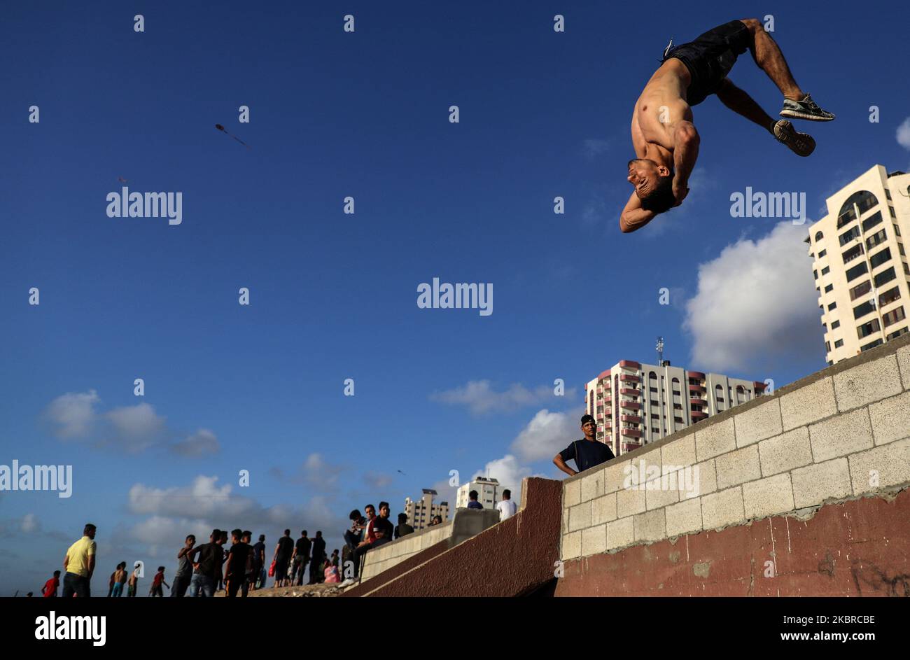 A Palestinian youth demonstrates his parkour skills on a beach amid