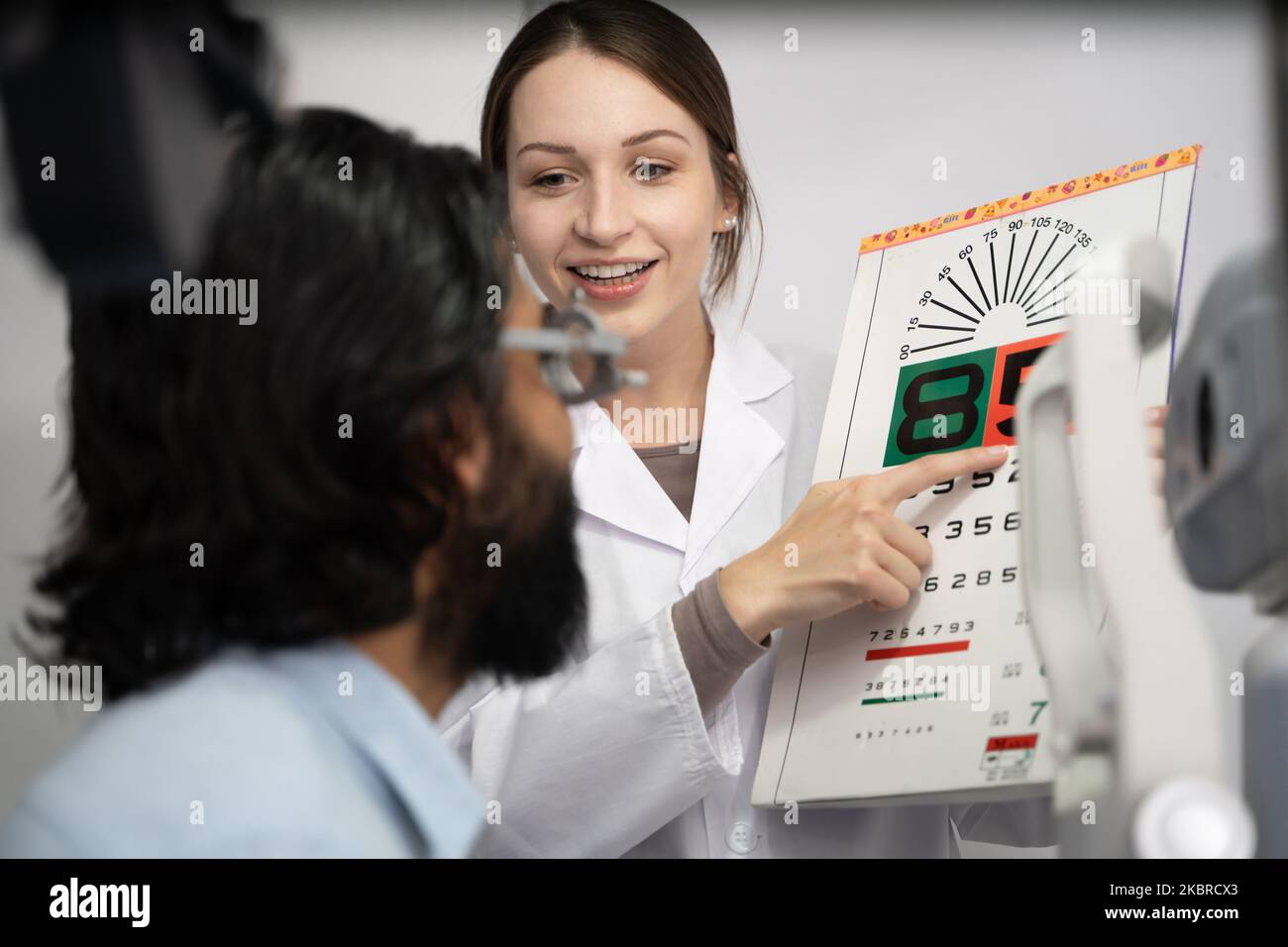 An eye doctor examines a male patient in a clinic with modern equipment. Stock Photo