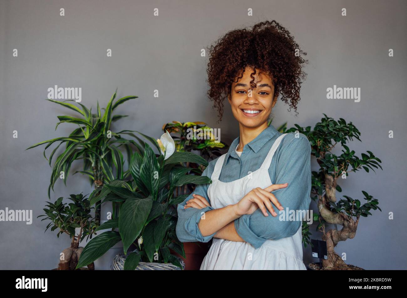 Young black woman wearing beige apron isolated on grey background with ...
