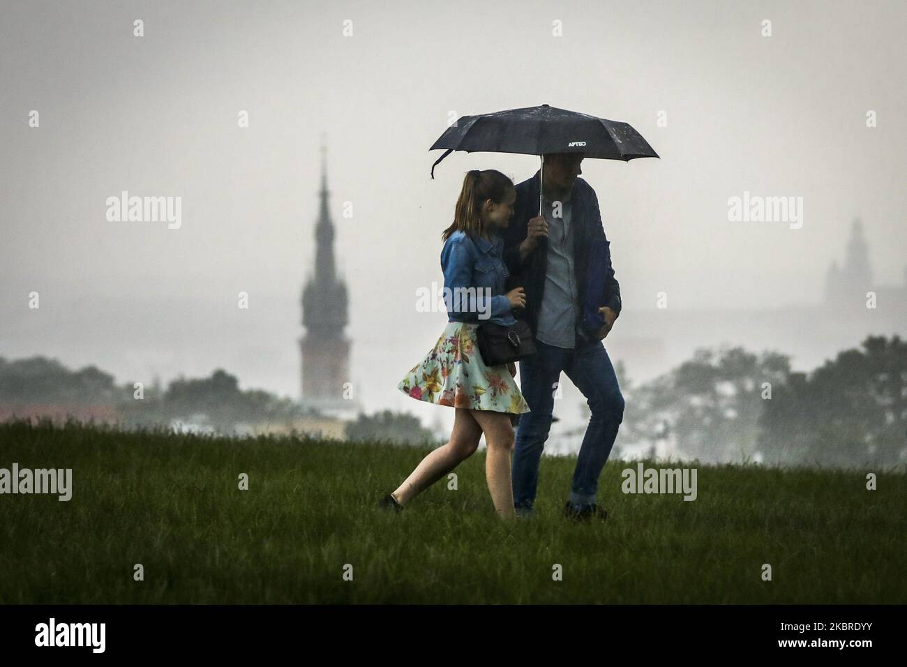 Heavy rain caught people walking near Krakus Mound on 'Kupala Night' in Krakow, Poland on June 20th, 2020. Kupala Night is a traditional eastern Slavic holiday related to the summer solstice on the shortest night of the Year. (Photo by Beata Zawrzel/NurPhoto) Stock Photo