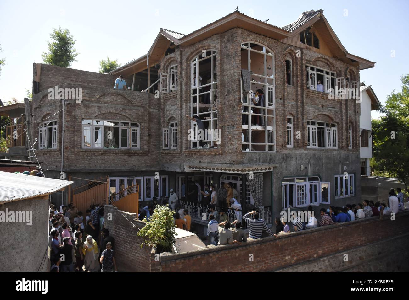 People arrive at the damage house where three rebels were killed in an encounter with Indian forces in Srinagar, Indian Admnistered Kashmir on 21 June 2020. (Photo by Muzamil Mattoo/NurPhoto) Stock Photo