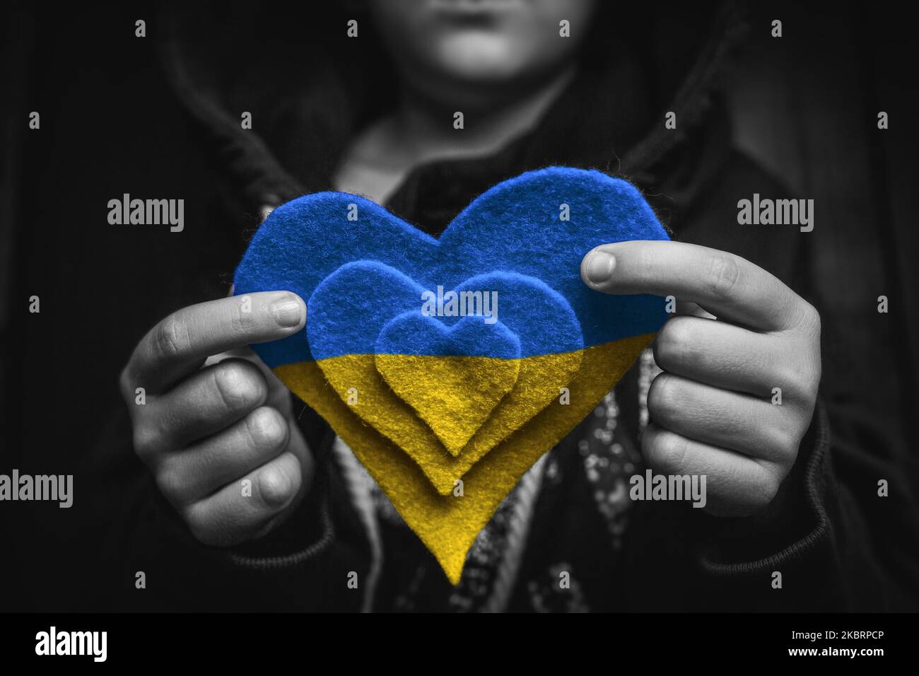 child holds blue yellow heart Stock Photo