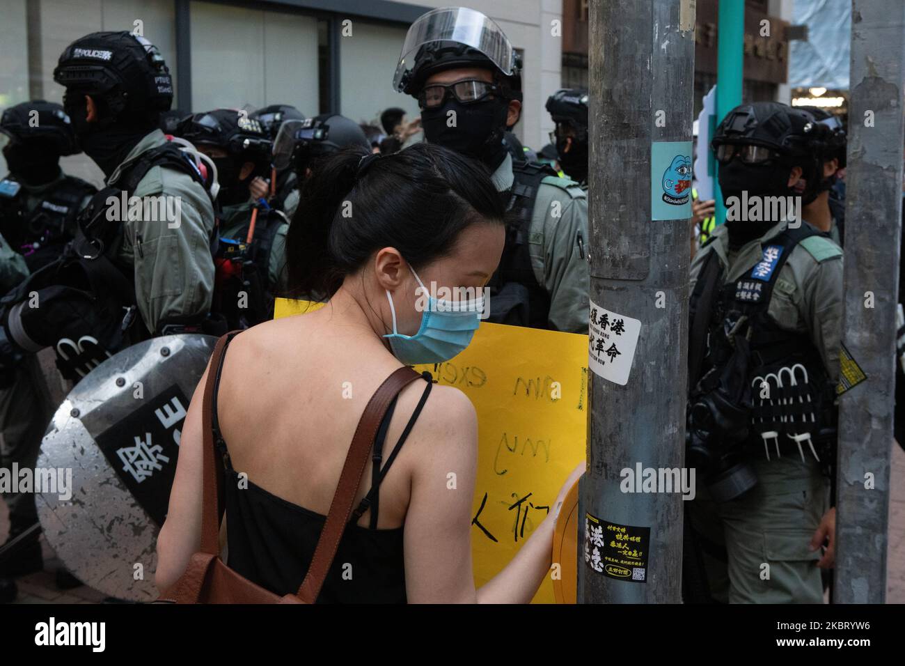 Protester hold's a sign 'I am exercising my Freedom of Assembly' while standing in front of riot police in Hong Kong, China, on July 1, 2020. (Photo by Simon Jankowski/NurPhoto) Stock Photo