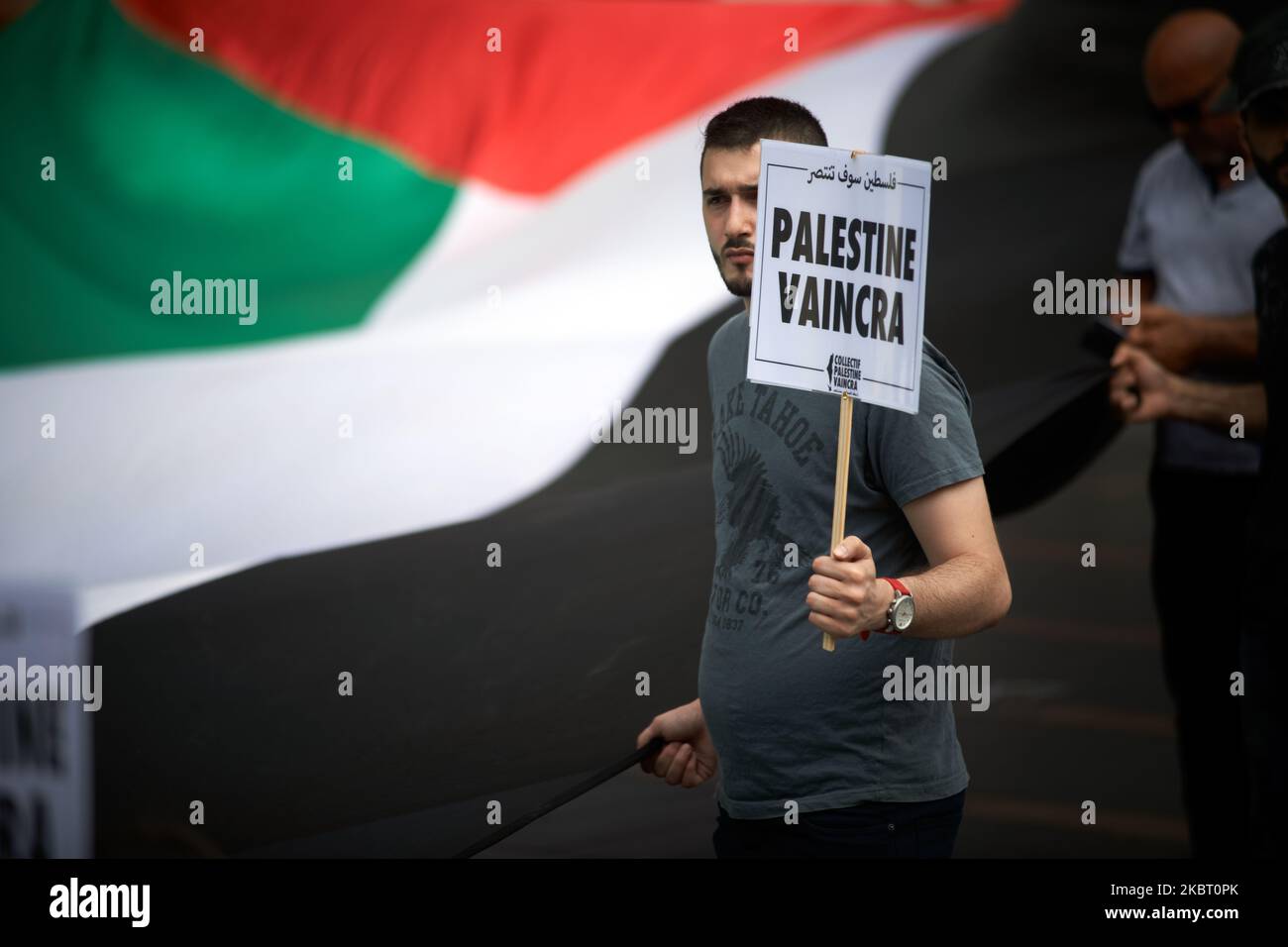 A man holds a giant Palestinian flag and a placard reading 'Palestine will prevail'. Supporters of Palestine organized a gathering in Toulouse against the planned annexion of parts of West Bank and the total annexion of the Jordan Valley by Netanyahu governement on July 1st 2020. Netanyahu said he follows the Trump-Kushner peace plan in Israel/Palestine. However, most of UN's countries oppose the move on legal ground.Sympathizers of Palestine promote also the BDS (Boycot, Desinvest, Sanction) movement which is legal in France since a decision of the European Justice Court. Toulouse. France. Ju Stock Photo