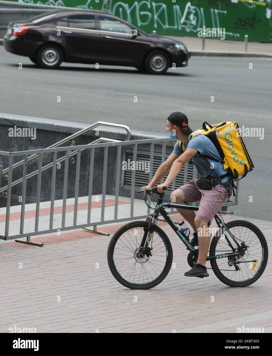 Glovo food delivery man on his bike is seen on the street in Kyiv