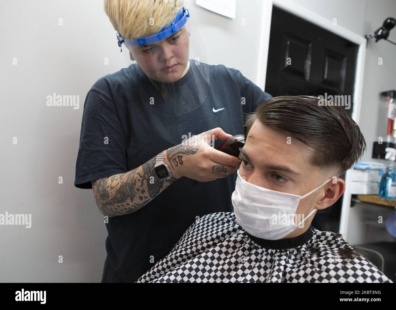 A man getting his hair cut at Jay's Barbers. Barbers' Shops and