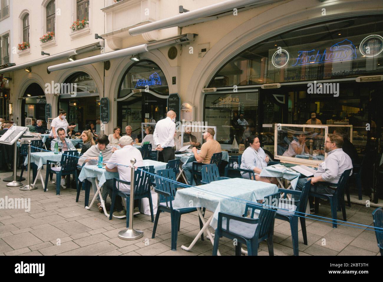 plastic dividers are installed between tables in a restaurant in