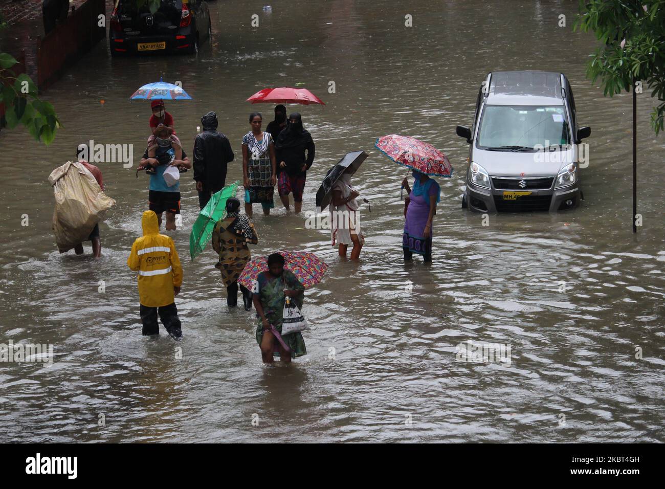 People wade through a flooded street during heavy rains in Mumbai ...