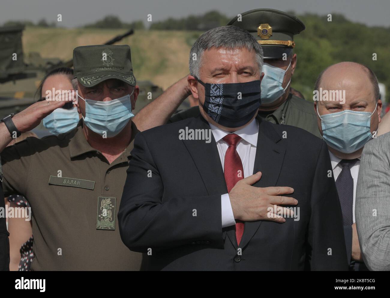 Internal minister Arsen Avakov (C) holds hand at heart while singing