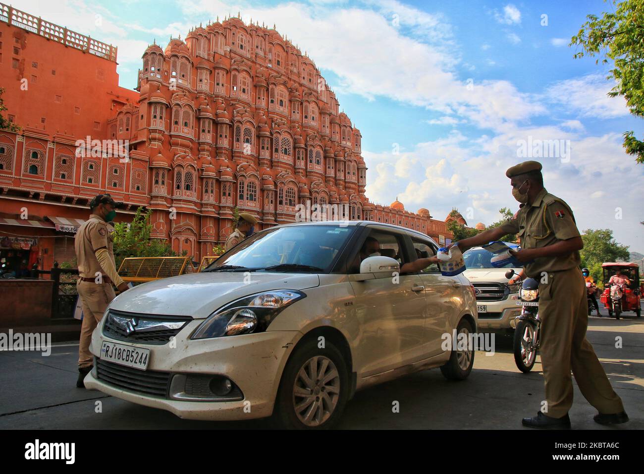 Security personnel distribute pamphlets to commuters during the