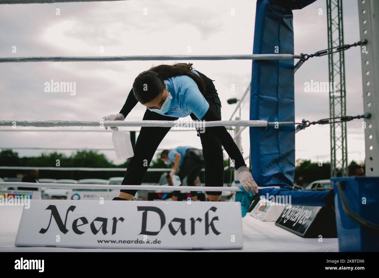 a staff with face mask clean the rings before the boxing fight in ...