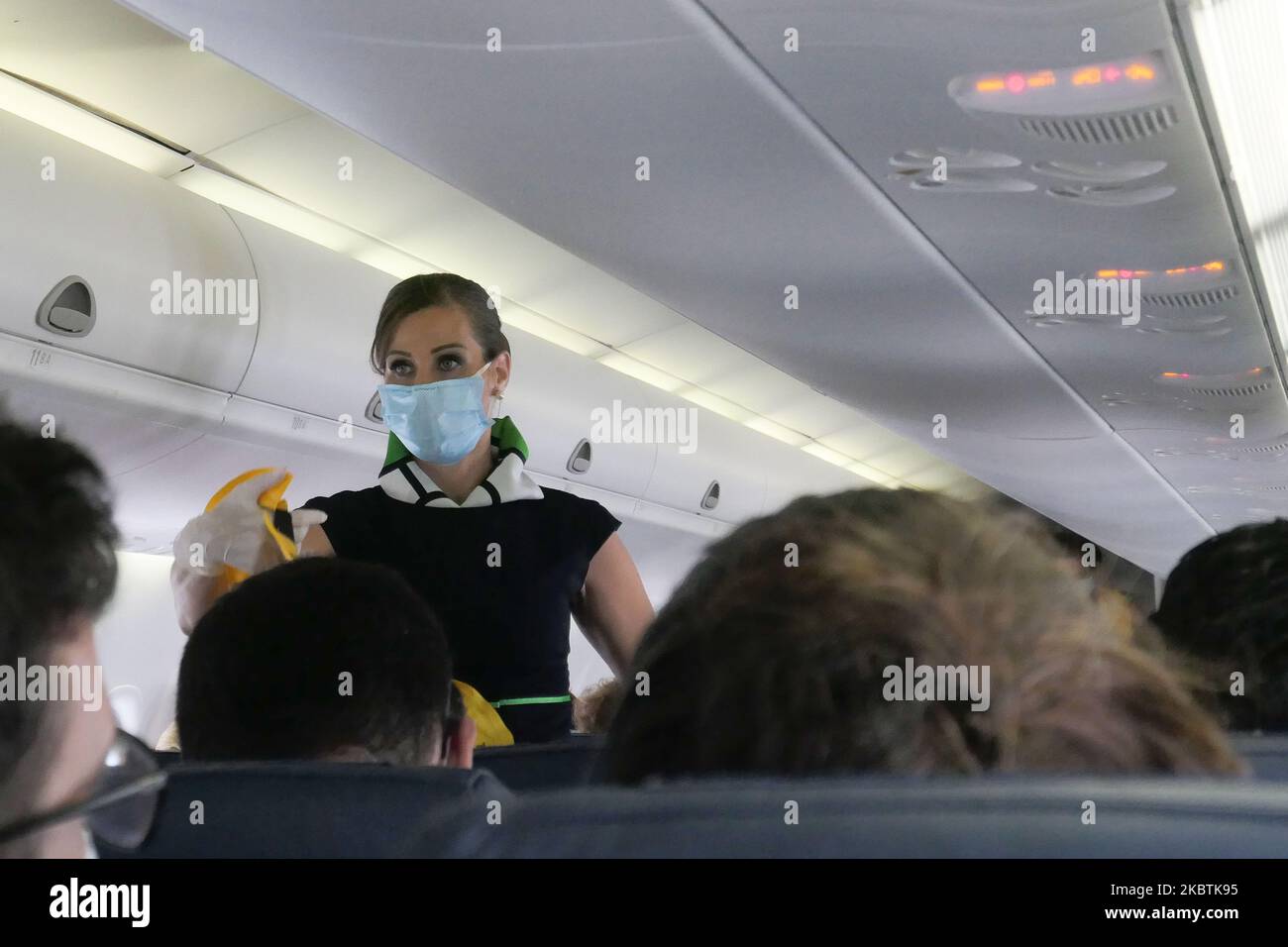 Cabin crew with facemask showing the safety demonstration. Flying in an
