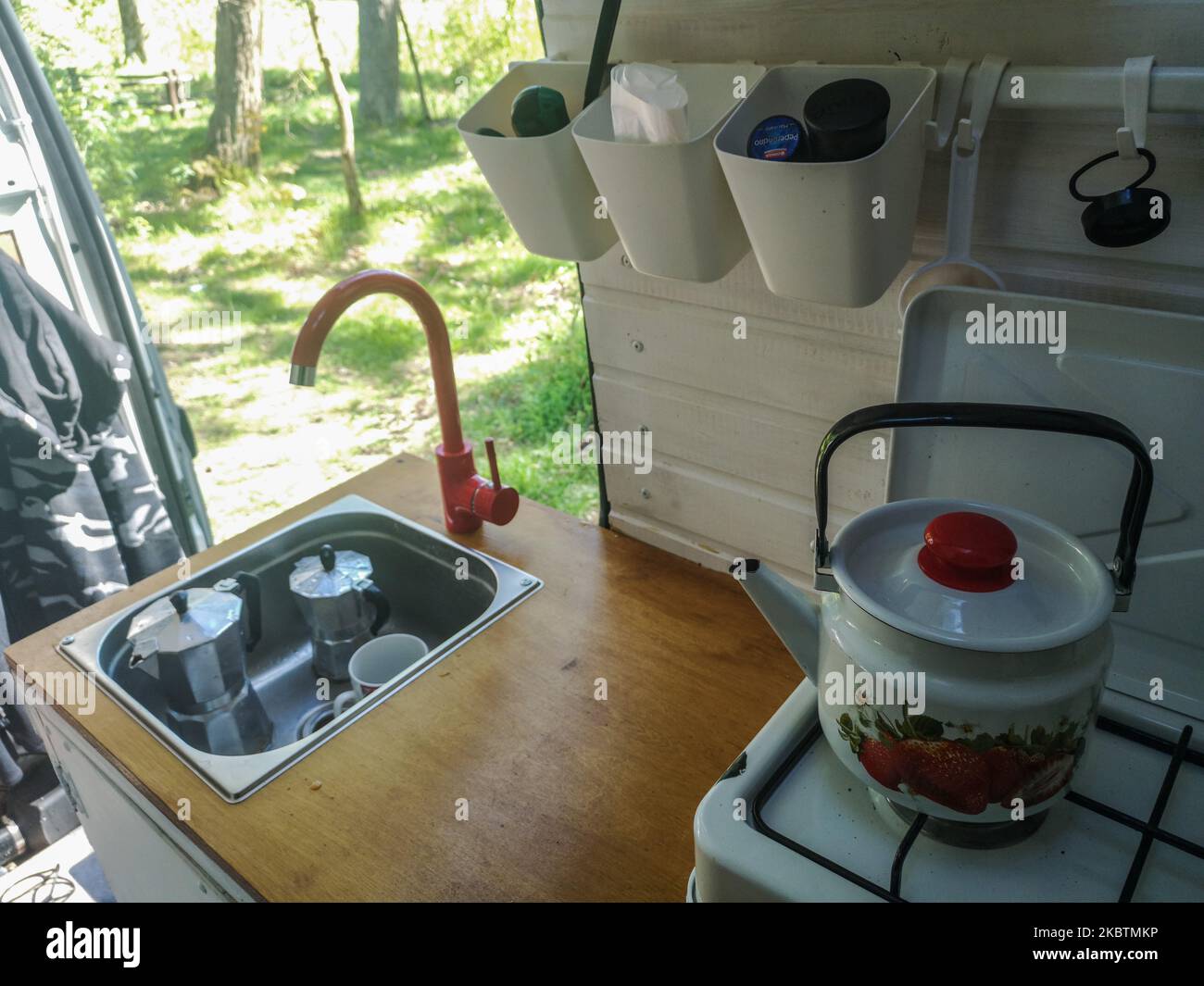 Kitchen unit inside the selfconverted camper van with USSR style kettle is seen in Oslonino