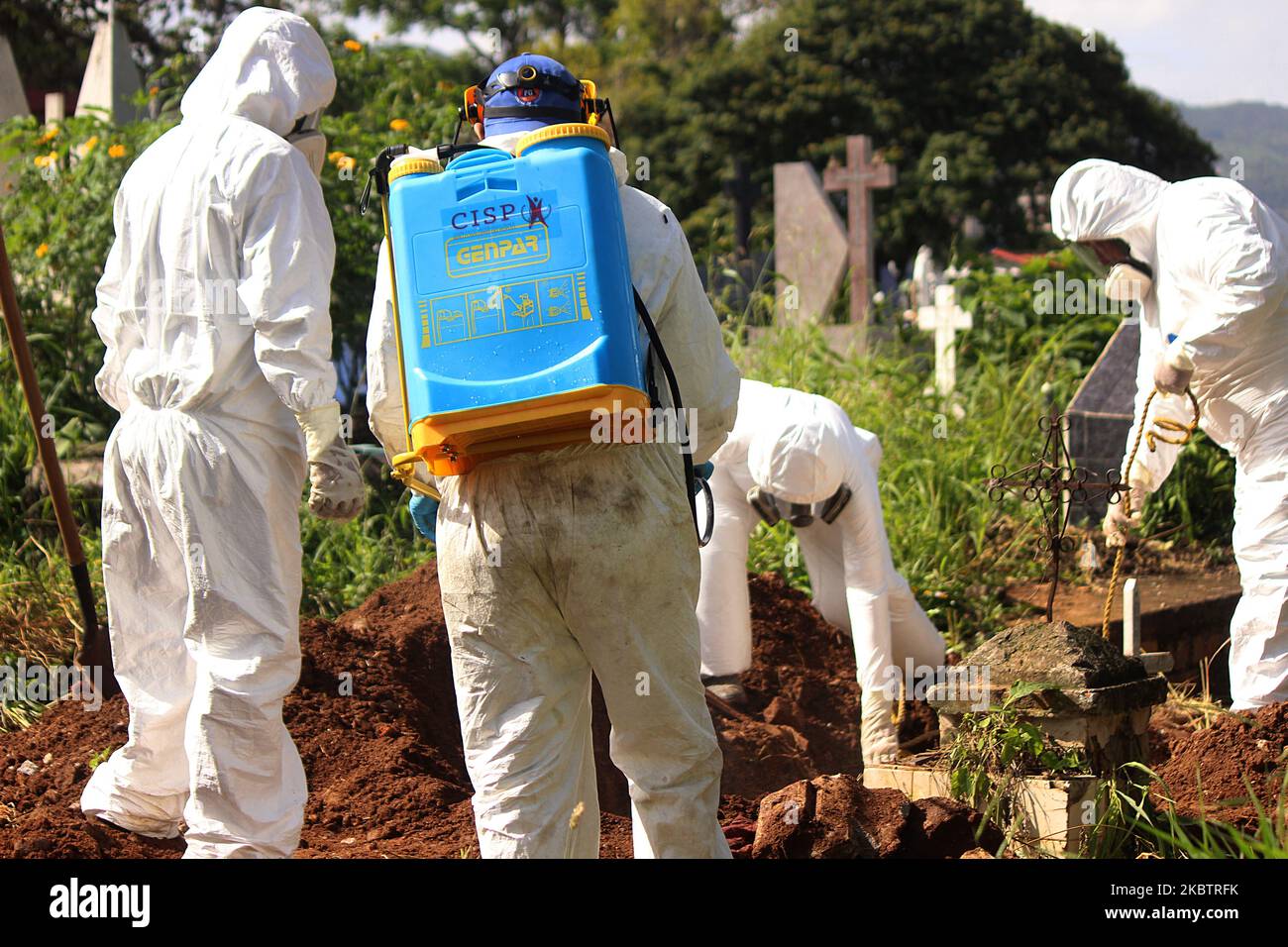 Civil protection officials and workers at the Municipal Cemetery comply with the protocol for the process of burying the body of a person deceased by COVID-19 in the city of San Cristóbal, Venezuela, July 15, 2020. By order of the Venezuelan government, all those who died from the disease must be buried in the municipality where he died, even if this person does not reside in this city. Venezuela's Vice President Delcy Rodriguez reported Wednesday that the Caribbean country registered four new deaths from COVID-19, as it reached 100 deaths from this disease since the first infections were dete Stock Photo