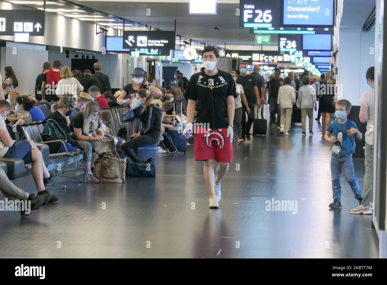 Passengers wearing facemasks, gloves and safety measures are seen on July 15, 2020 at the terminal, F Gates area of Vienna International Airport VIE LOWW - Flughafen Wien-Schwechat serving the Austrian Capital but also Bratislava as it is 55km away from the Slovak city during the Covid-19 Coronavirus pandemic era with social distancing measures and disinfecting hand sanitizer everywhere afther the lockdown period. On July 1, Austria issues travel warning for six Balkan states countries, Serbia, Montenegro, Bosnia Herzegovina, North Macedonia, Albania and Kosovo. Passengers traveling from those Stock Photo