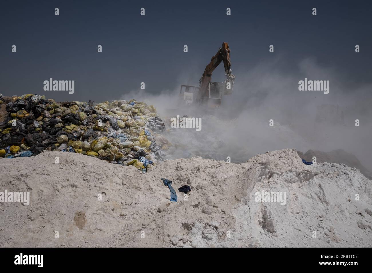 A loader covers infectious wastes with lime in Tehran Garbage Disposal