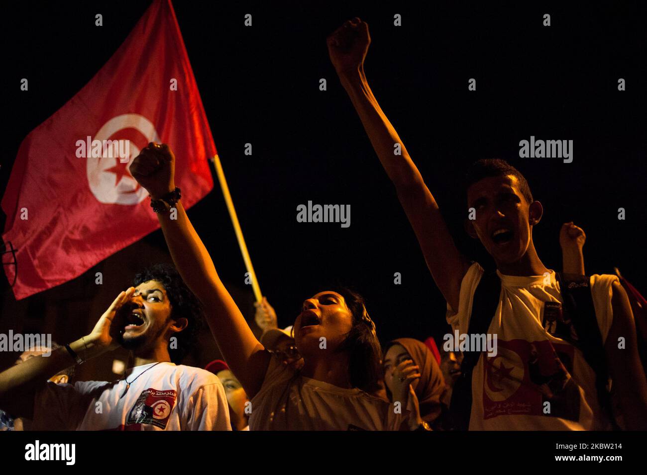 People wave a tunisien flag during a march outside the National Assembly at the bardo to mark the 40th day since the assassination of opposition politician Mohamed Brahmi. Brahmi was shot dead by unknown gunmen outside his home. On 7 September 2013, in Tunis, Tunisia. (Photo by Emeric Fohlen/NurPhoto) Stock Photo