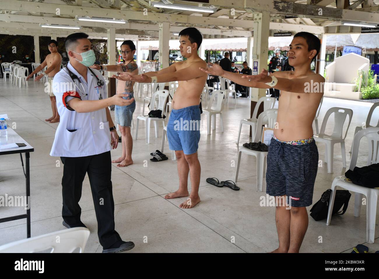 Men attend to physical examination by an army doctor for conscript into