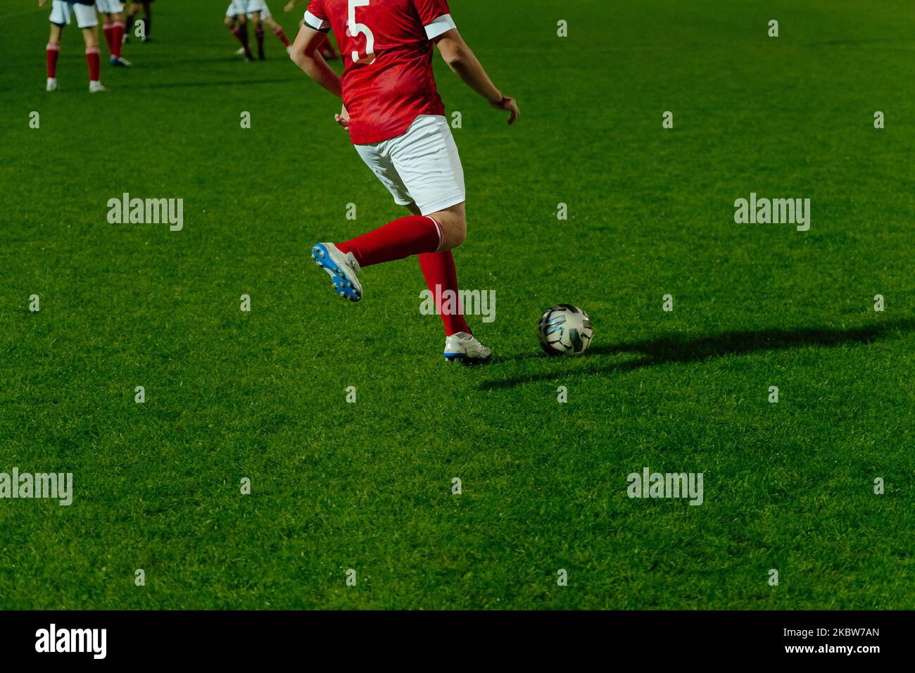 football player hits ball during football match Stock Photo