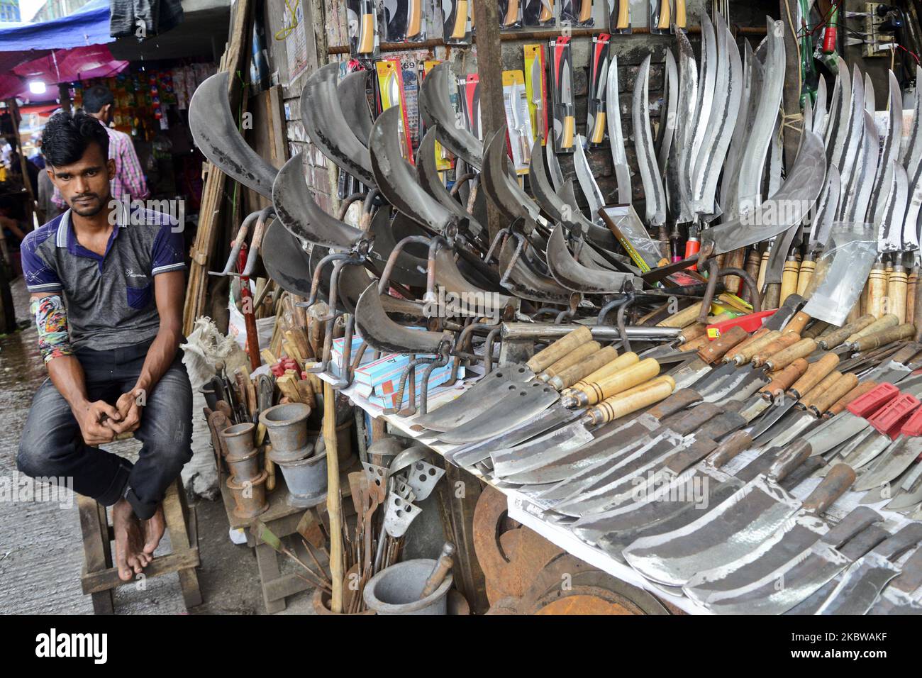 A Bangladeshi shopkeeper waits for customer in a knives shop at market