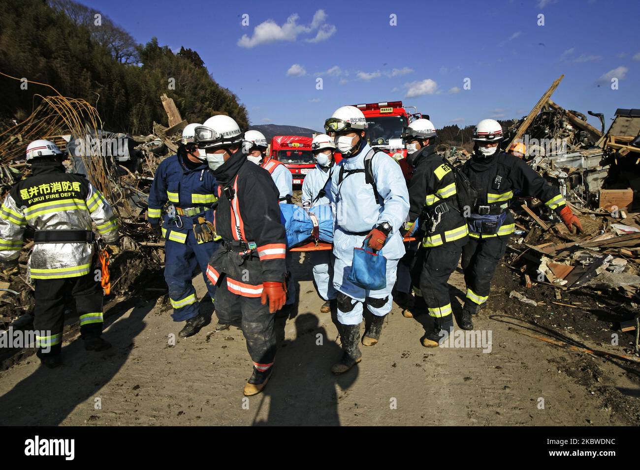 March 18, 2011-Rikuzen Takata, Japan-Rescue Team carry exhumed body on debris and mud covered at Tsunami hit Destroyed city in Rikuzentakata on March 18, 2011, Japan. On 11 March 2011, an earthquake hit Japan with a magnitude of 9.0, the biggest in the nation's recorded history and one of the five most powerful recorded ever around the world. Within an hour of the earthquake, towns which lined the shore were flattened by a massive tsunami, caused by the energy released by the earthquake. With waves of up to four or five metres high, they crashed through civilians homes, towns and fields. (Phot Stock Photo