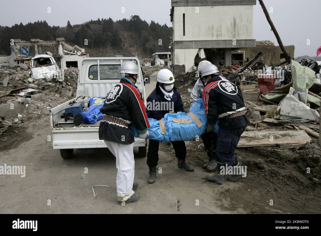 March 20, 2011-Rikuzen Takata, Japan-Volunteer Rescue Team Carry exhumed body on debris and mud covered at Tsunami hit Destroyed city in Rikuzentakata on March 20, 2011, Japan. On 11 March 2011, an earthquake hit Japan with a magnitude of 9.0, the biggest in the nation's recorded history and one of the five most powerful recorded ever around the world. Within an hour of the earthquake, towns which lined the shore were flattened by a massive tsunami, caused by the energy released by the earthquake. With waves of up to four or five metres high, they crashed through civilians homes, towns and fie Stock Photo