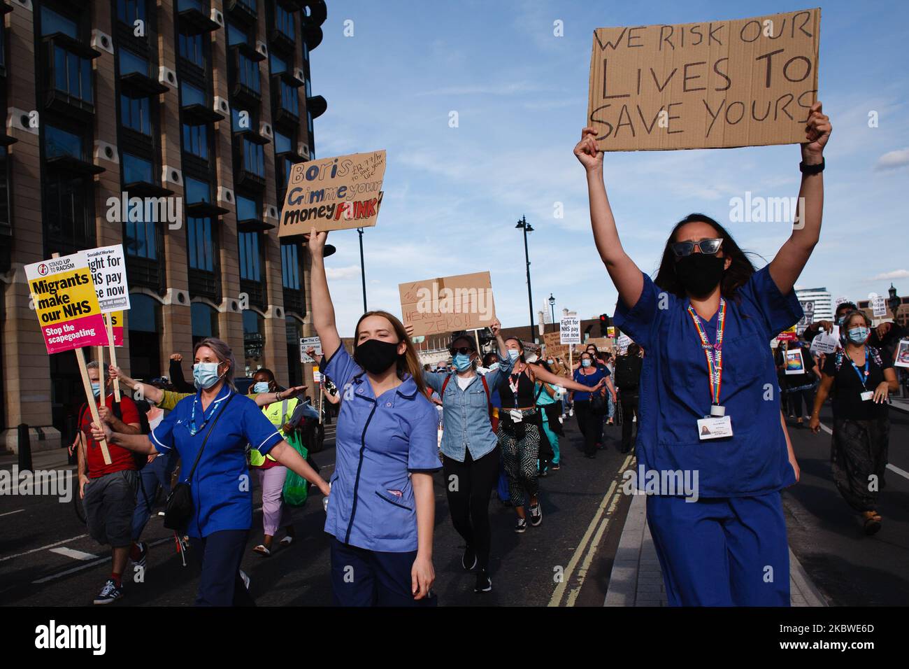 National Health Service (NHS) staff, protesting their exclusion from a recently-announced public sector pay rise, march into Parliament Square bound for Downing Street in London, England, on July 29, 2020. Around 900,000 public sector workers across the UK are set to receive above-inflation pay rises this year as a gesture of thanks from the Treasury for their efforts during the coronavirus pandemic. Within the NHS, doctors and dentists will benefit from the rises, but nurses and other frontline staff have been excluded owing to a three-year pay deal they negotiated in 2018. Nursing activists  Stock Photo