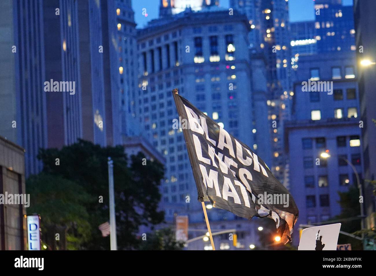 People wearing masks are seen protesting near City Hall as New York