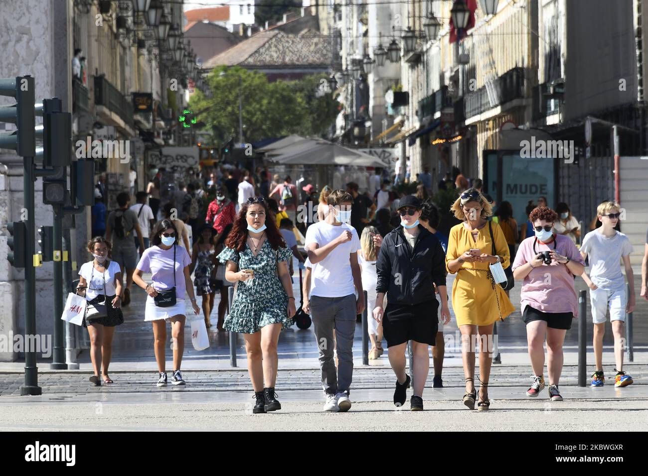 Tourists wearing protective masks walk near Praça de Comércio, Lisbon. July 31th, 2020. Health Minister Marta Temido reported that there are 12,864 active cases of COVID-19 disease in Portugal, including outbreak-related infections. In total there are 194 active outbreaks in the country: 47 in the North region, 12 in the Centre, 106 in Lisbon and Tagus Valley, 14 in the Alentejo and 15 in the Algarve region. The outbreaks are considered active even if several days have passed since the last confirmed case. 'We only consider an outbreak to be extinct when 28 days (two incubation periods) have p Stock Photo