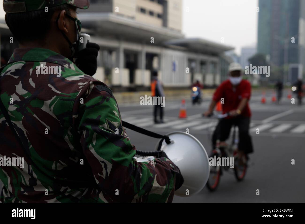 Member of Indonesian Army wearing face mask, talk in loud speaker to remainding people to keep maintain health protocols, such as wearing face, keeping a distance, and using hand sanitizer or washing their hands, during their activities amid the spread of coronavirus Covid-19 at Hotel Indonesia roundabout areas, Jakata, on August 2, 2020. (Photo by Aditya Irawan/NurPhoto) Stock Photo