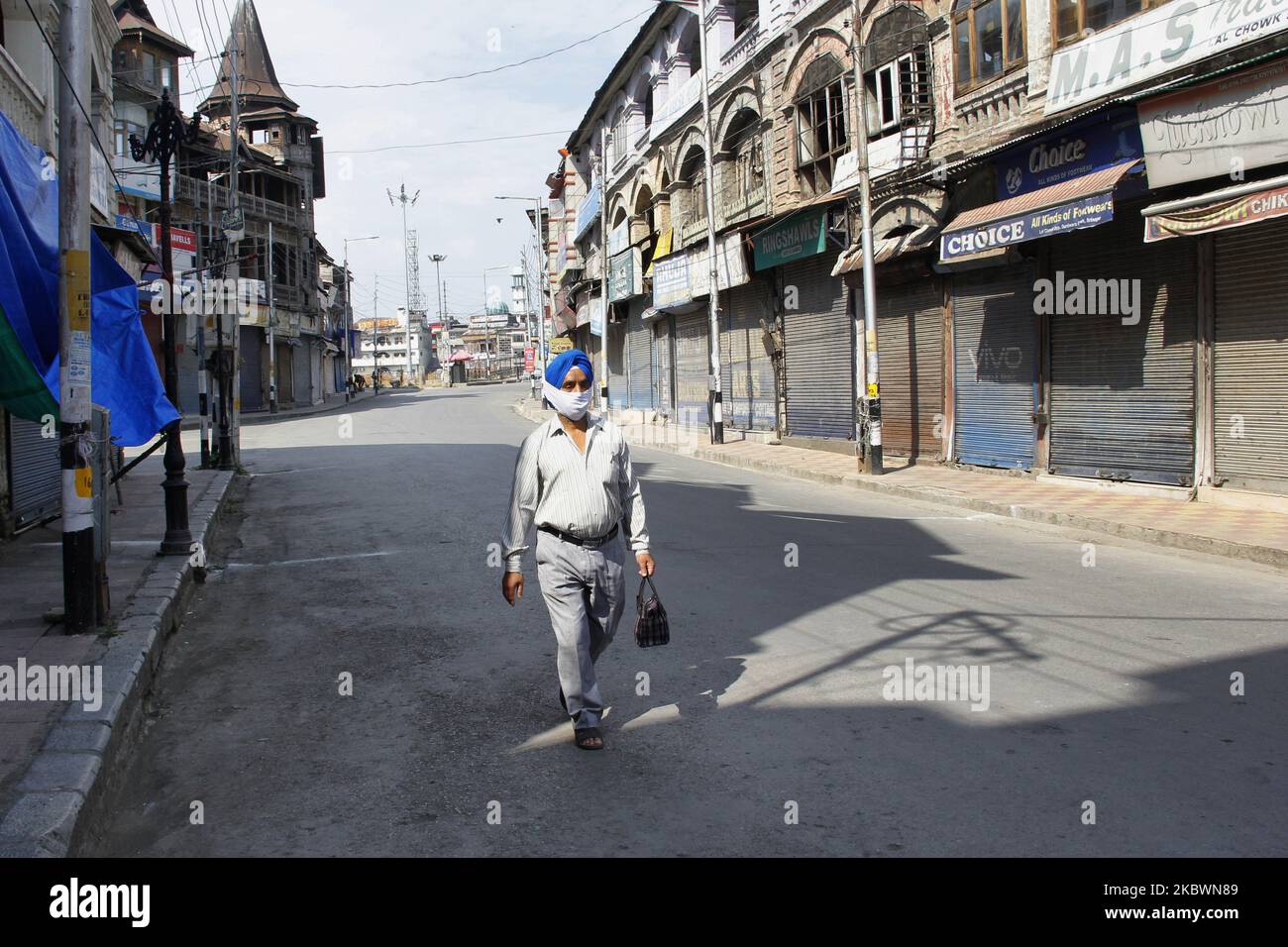 A man walks on a deserted street during strict restrictions in Srinagar, Indian Administered Kashmir on 04 August 2020. Two days curfew has been put in place by authorities on a year anniversary of abrogation of Article 370 which gave special status to the people of Kashmir, curefew was placed on 04th and 5th August citing possibility of the protests in the valley. (Photo by Muzamil Mattoo/NurPhoto) Stock Photo